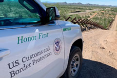 The passenger side door of a US Customs and Border Protection vehicle in the dessert