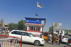 A Taliban flag flies in the main square of Kunduz, Afghanistan, after fighting between Taliban and Afghan security forces on Aug. 8. (Abdullah Sahil/AP)