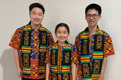 Left to right: James Lin, Yuka Machino, and Holden Mui wear customized kente stole during their time in Ghana for IAP 2022.