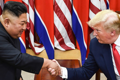 North Korea's leader Kim Jong Un, left, and US President Donald Trump shake hands during a meeting on the southern side of the DMZ [Brendan Smialowski/AFP]